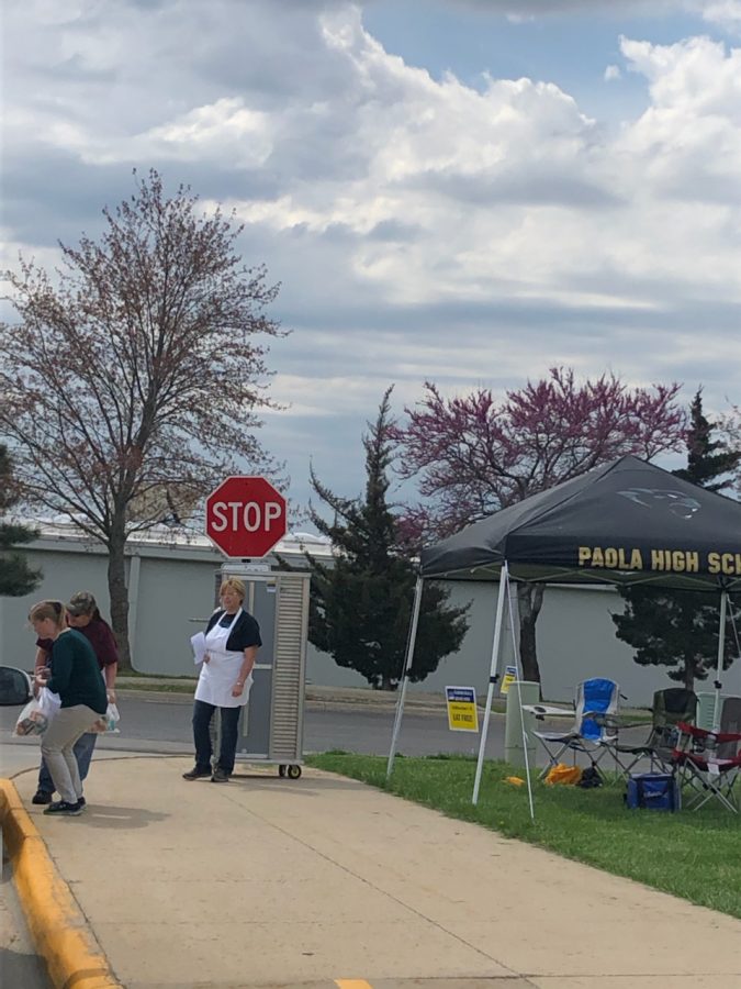 Parents drive through the high school parking lot during meal pickup provided by USD 368 for breakfast and lunch for children ages 1-18 on April 2. Food service workers enjoyed helping families in need and seeing familiar faces again, said Rita Wobker, food service worker. 